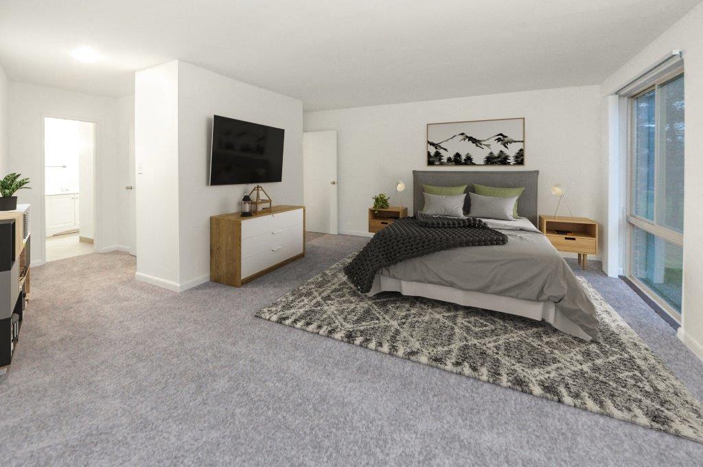 a bedroom with a bed and a television on the wall
