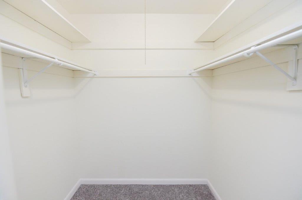 an empty room with white walls and a carpet