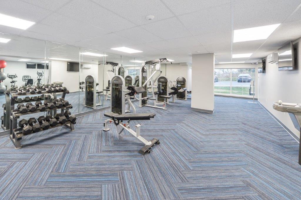 a gym with weights and cardio equipment in a building
