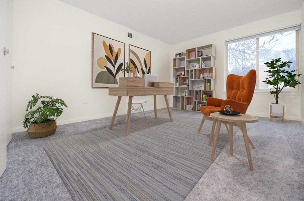 a living room with a desk and chairs and a window