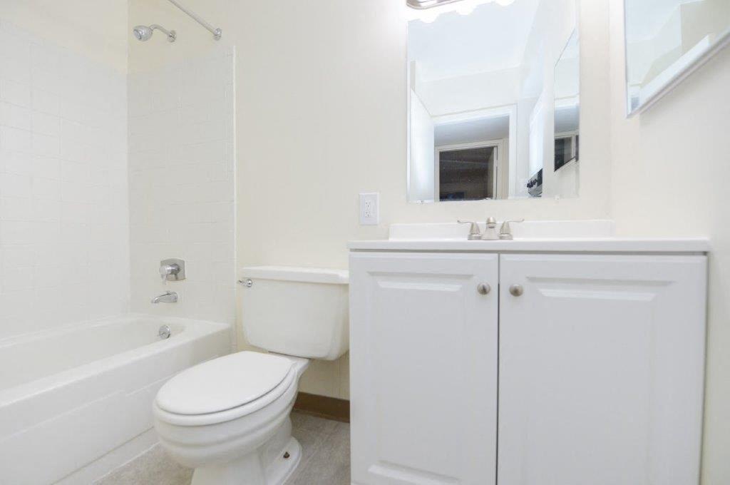 a white bathroom with a toilet and a sink