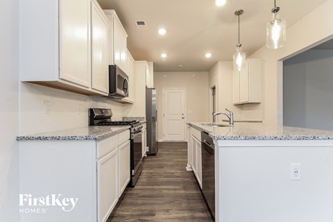 a kitchen with white cabinets and a counter top and a sink