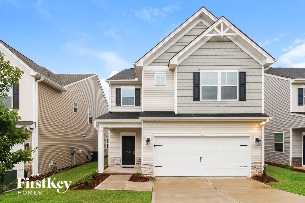 a beige and gray house with a white garage door