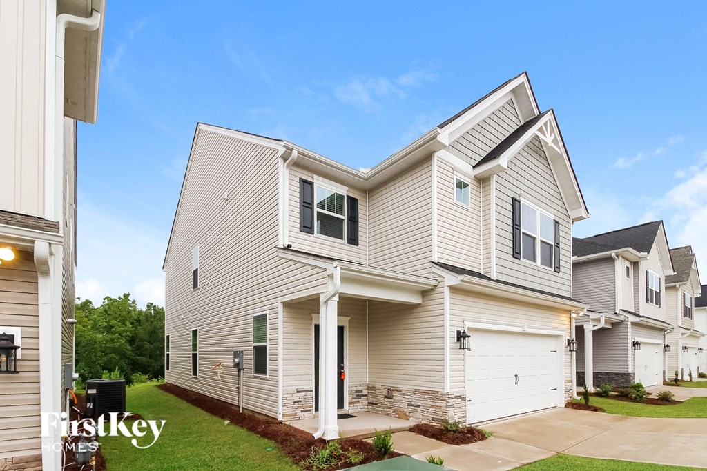 two story house with white siding and a yard