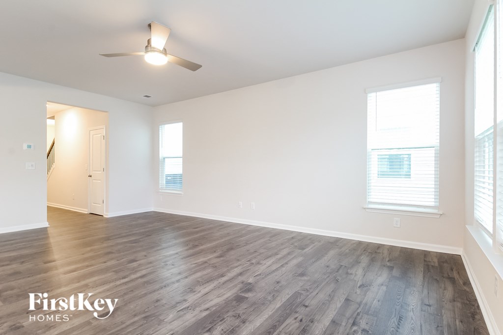 an empty living room with white walls and wood floors