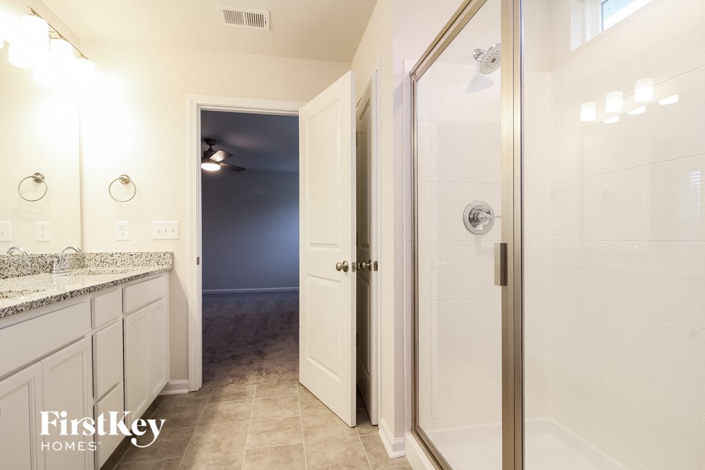 a white bathroom with a shower and a sink