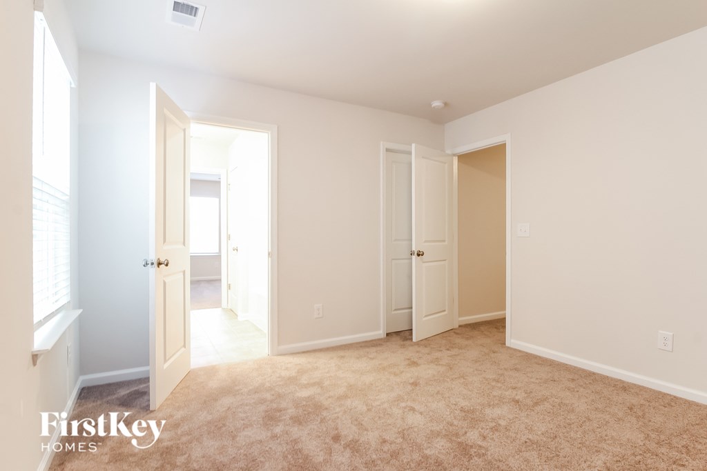 a master bedroom with two closets and a carpeted floor