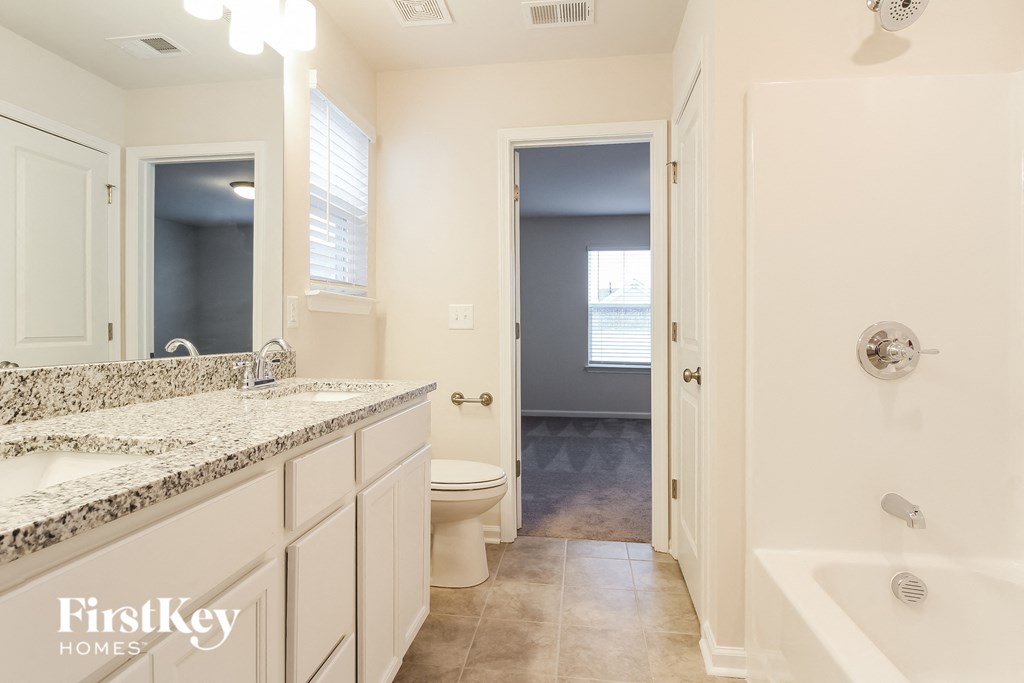 a bathroom with a toilet and a sink and a shower