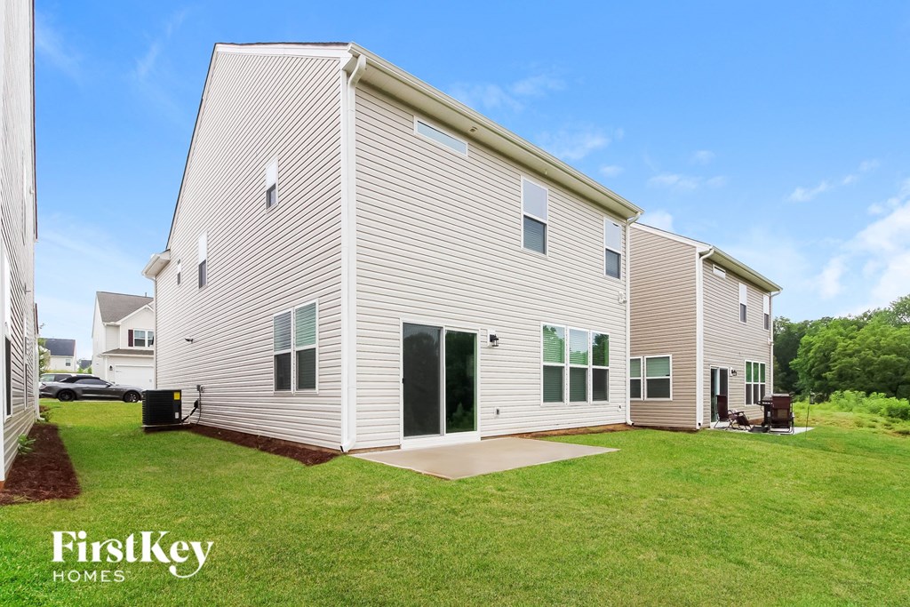 a white house with a green lawn and a blue sky