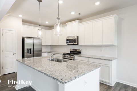 A kitchen with granite countertops and white cabinets.