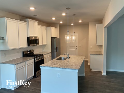 A kitchen with white cabinets and a granite countertop.