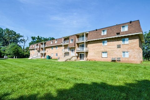 a large brick apartment building with green grass