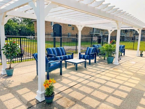 a patio with chairs and a table under a white canopy