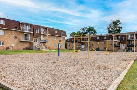 an empty playground in front of an apartment building