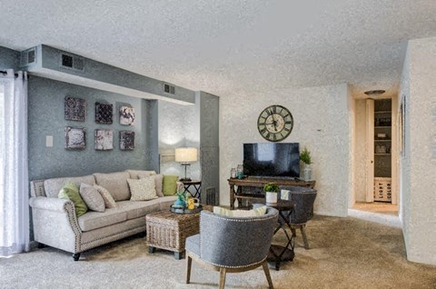 a living room with a couch and chairs and a television