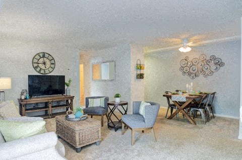 a living room and dining room with a large clock on the wall