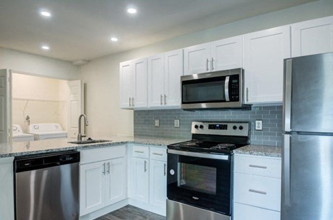 a kitchen with stainless steel appliances and white cabinets