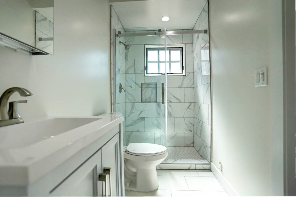 a bathroom with a shower and a sink and a toilet