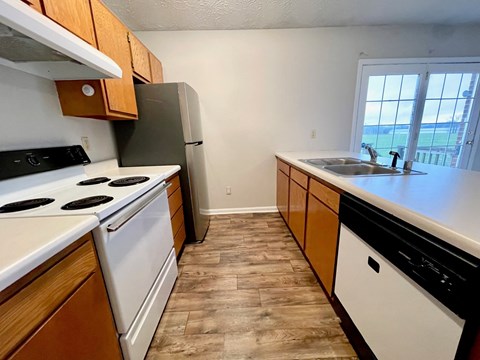 a kitchen with white appliances and wooden cabinets