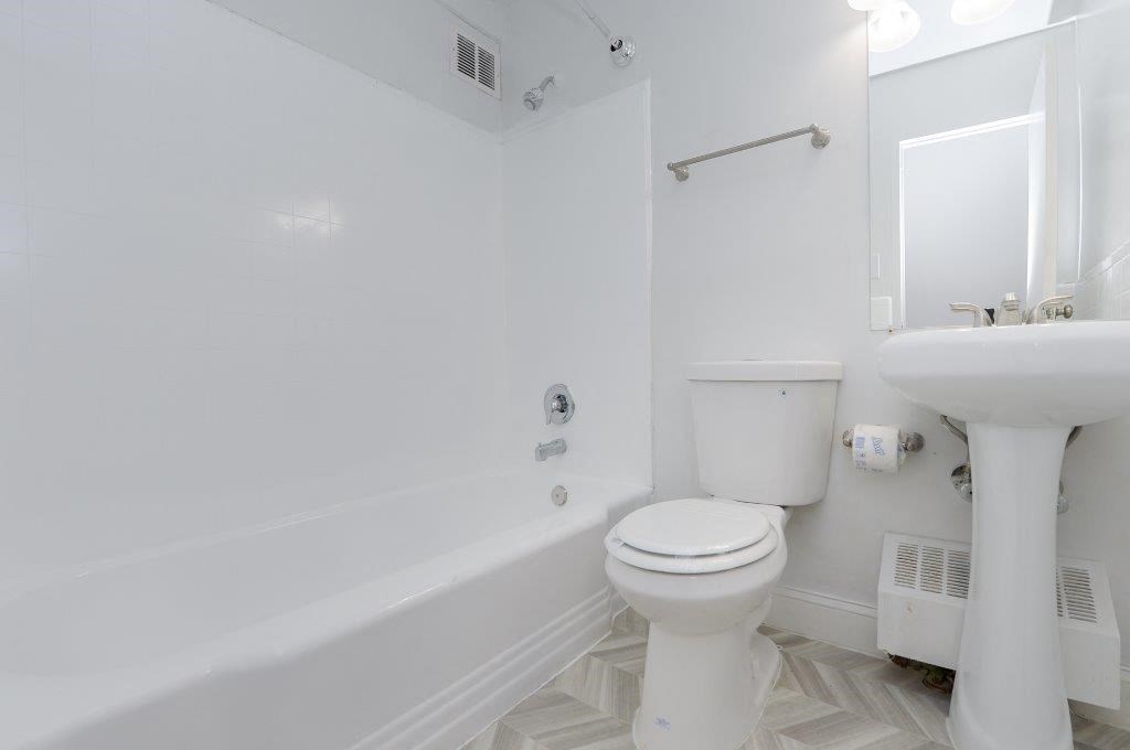 a white bathroom with a toilet and a sink