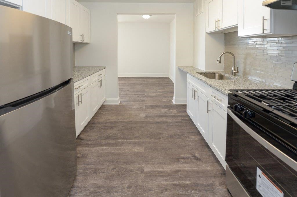 a kitchen with white cabinets and stainless steel appliances