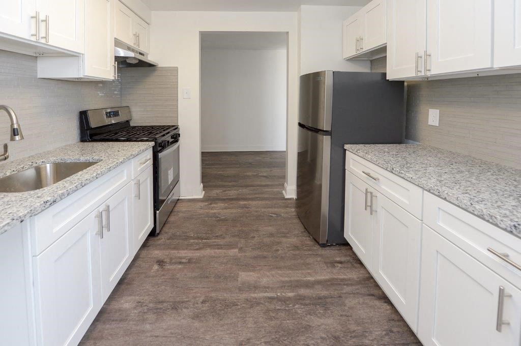 a kitchen with white cabinets and a stainless steel refrigerator