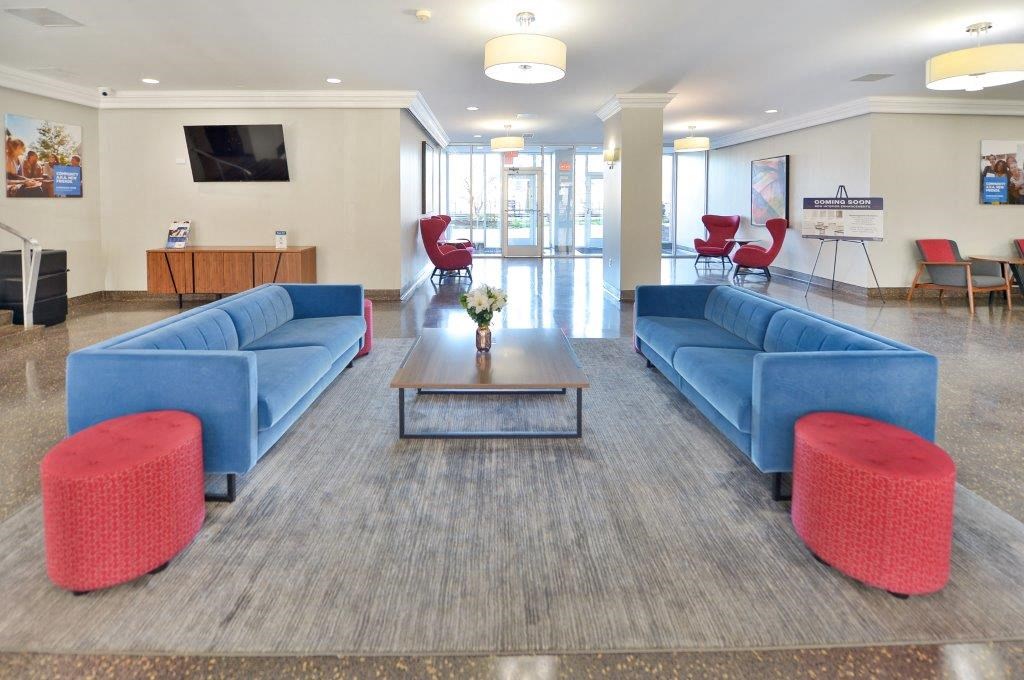 a lobby with blue couches and chairs and a table