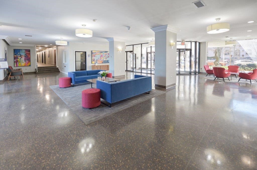 the lobby of a building with a blue couch and chairs