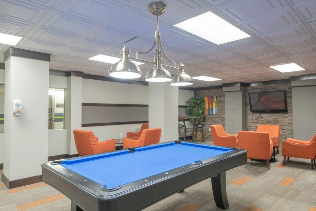 a game room with a pool table and chairs