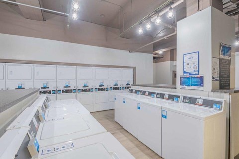 a laundry room filled with lots of white washing machines
