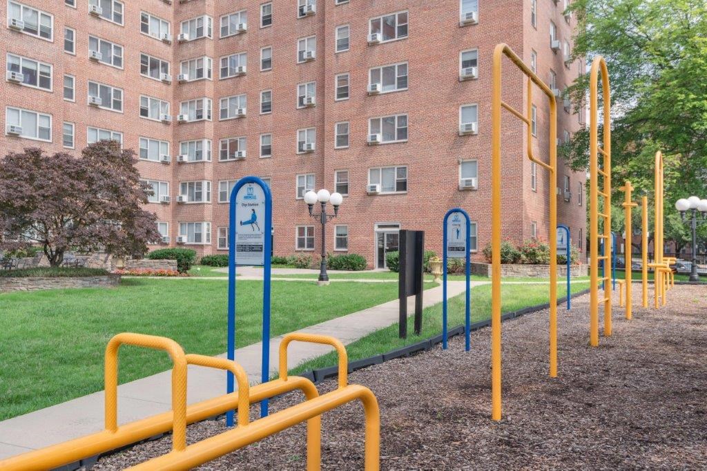 a row of playground equipment in front of a brick building