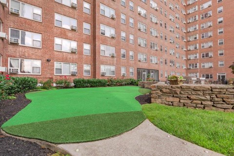an exterior view of a brick building with a green lawn