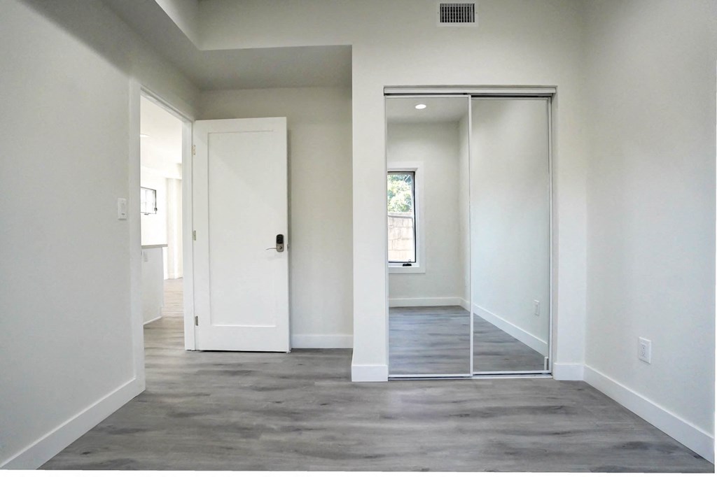 an empty room with white walls and a sliding glass door