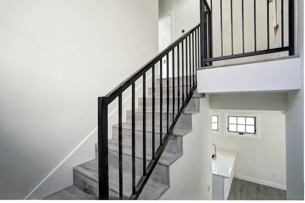 a spiral staircase in a home with white walls and black railings