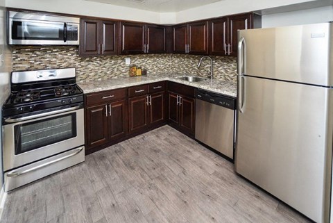 a kitchen with stainless steel appliances and wooden floors