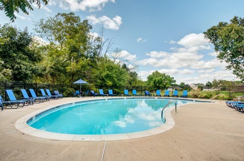a swimming pool with blue chairs around it