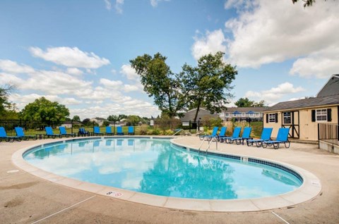 a swimming pool with blue chairs around it