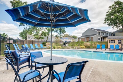 our apartments have a pool and patio with chairs and umbrellas