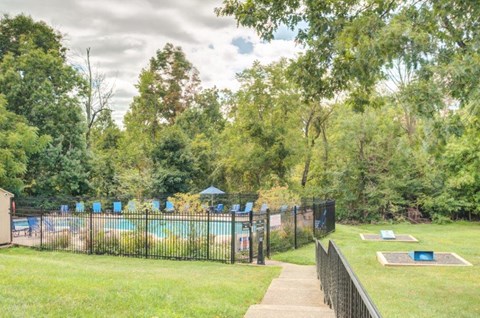 a park with a pool and trees and a fence