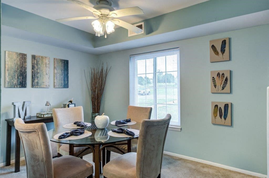 a dining room with a table and chairs and a ceiling fan