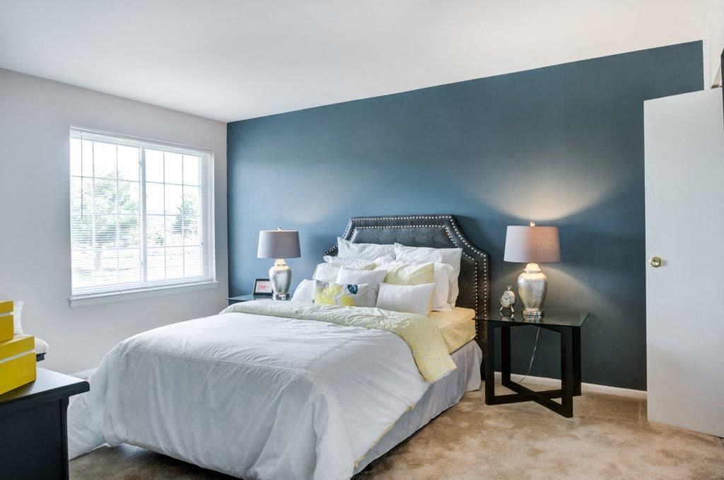 a bedroom with a bed and a blue wall