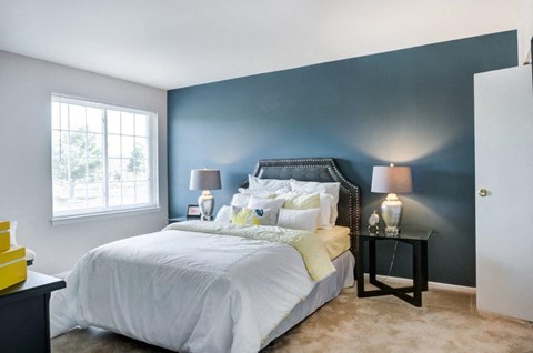 a bedroom with a bed and a blue wall