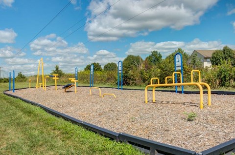a playground with yellow equipment in a park