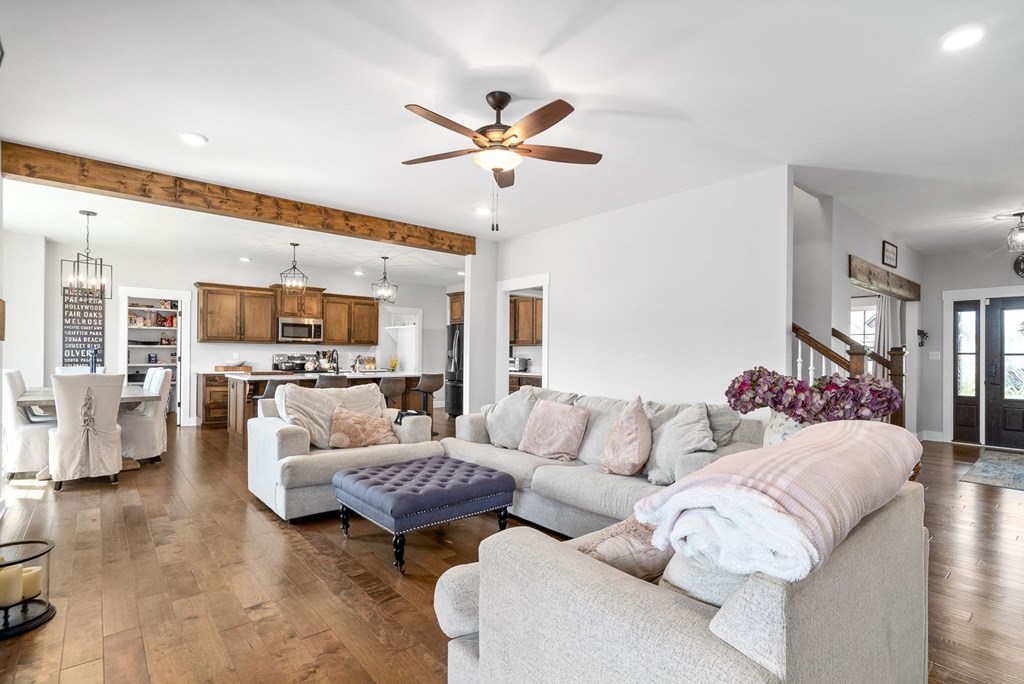 a living room with couches and a ceiling fan