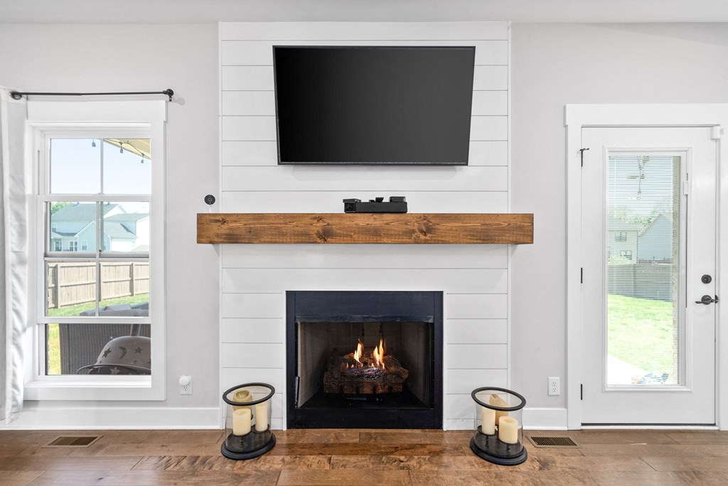 a living room with a fireplace and a tv above it
