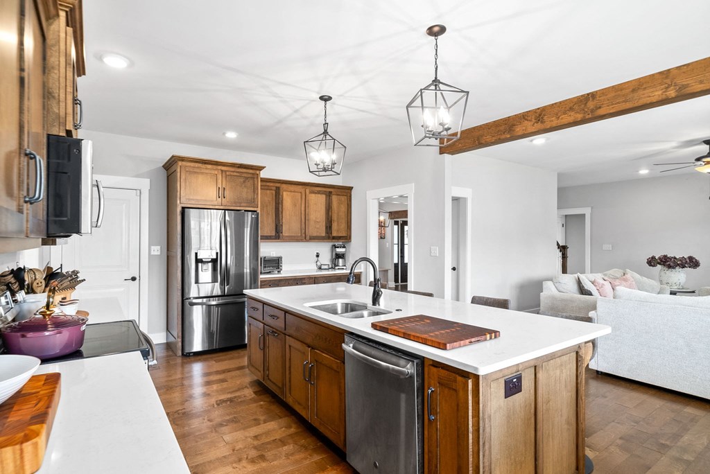 a kitchen with a large island and a stainless steel refrigerator