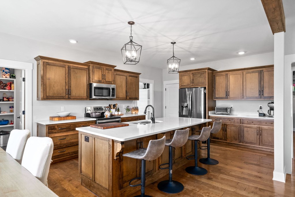 a kitchen with wooden cabinets and a large island with chairs