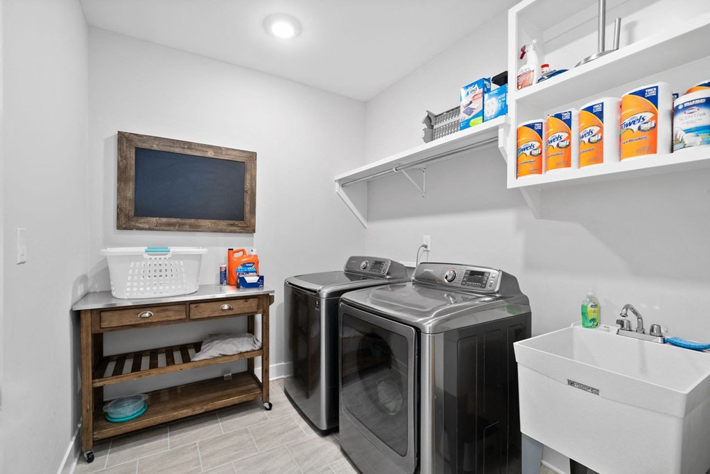 a laundry room with two washes and a sink and a dryer