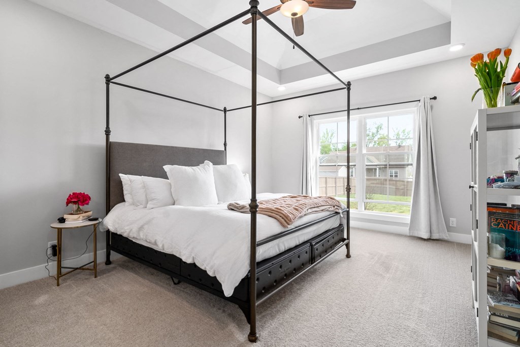 a bedroom with a bed and a large window