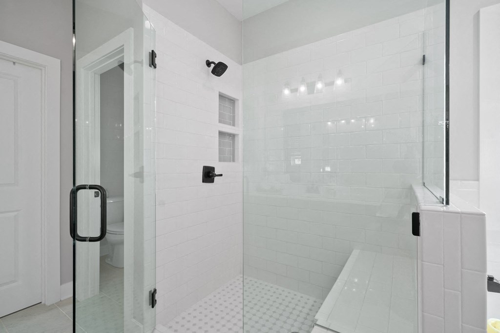a large white bathroom with a shower and a toilet